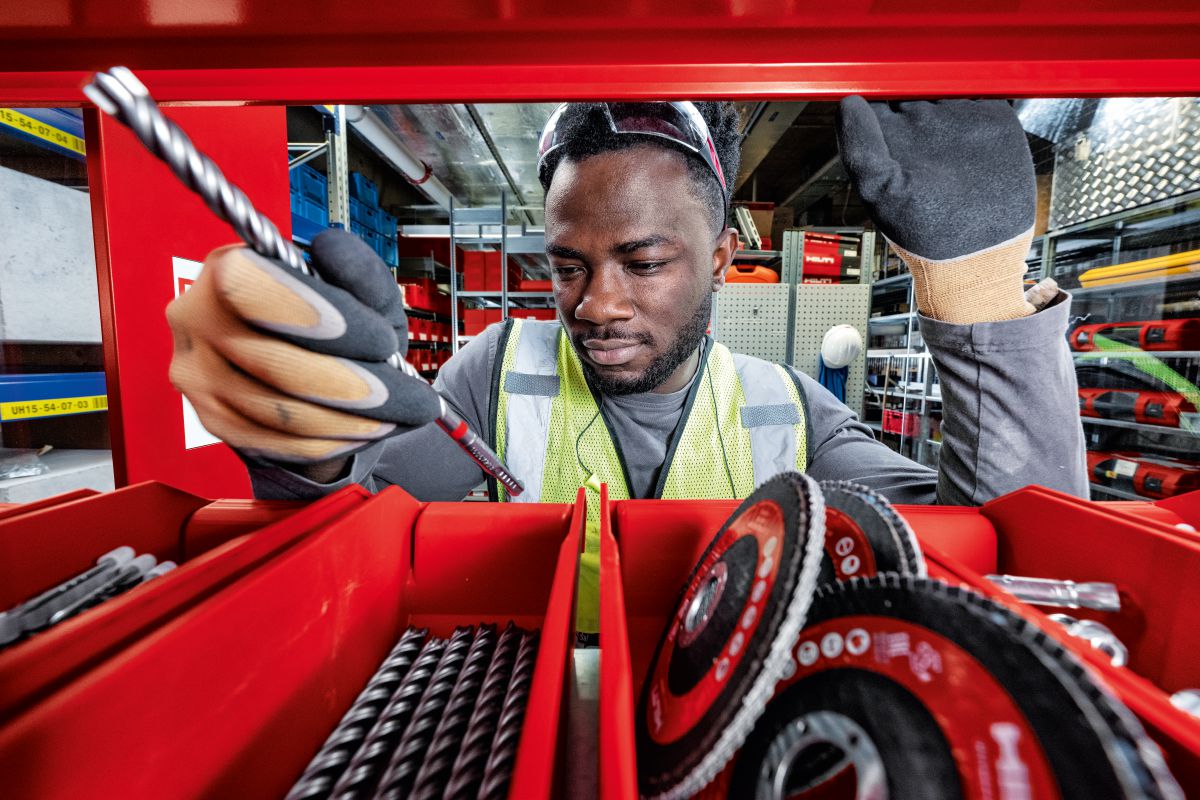 Man looking inside connected smart locker and checking drill bit