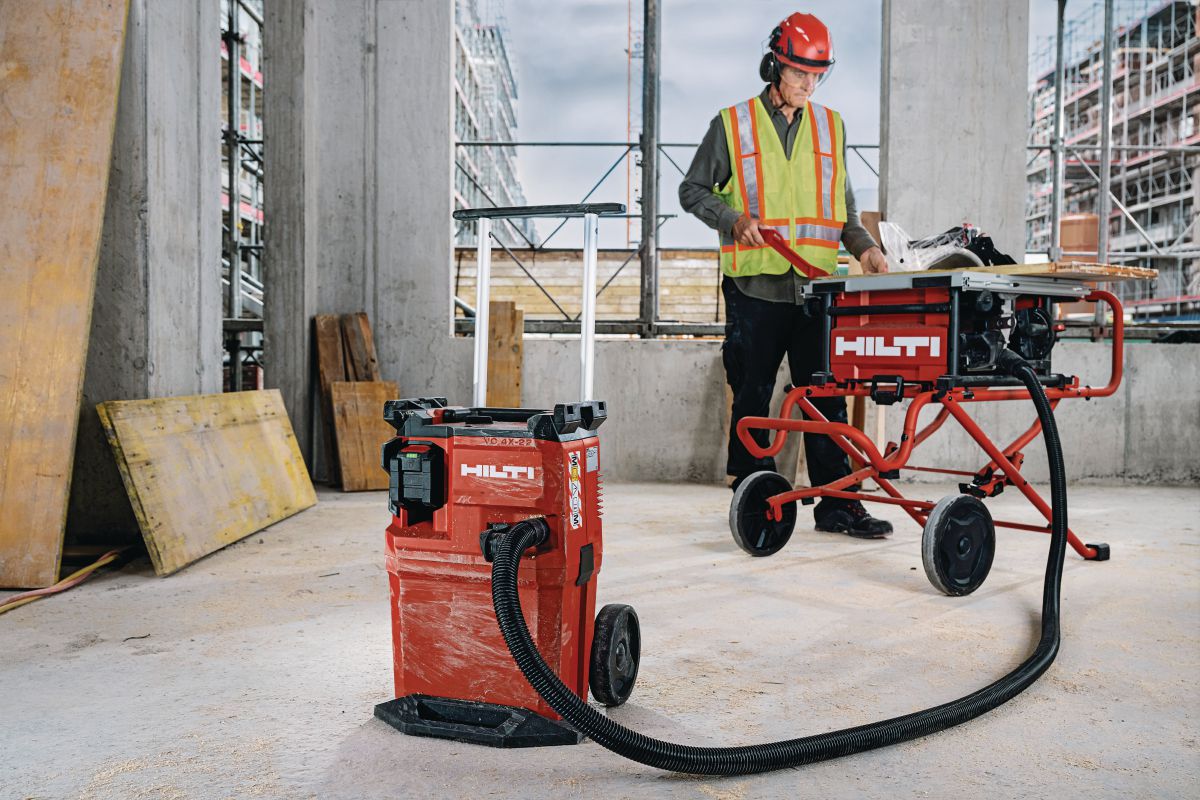 Application image of VC 4X-22 PK vacuum cleaner and table saw SCT 60-22 (G01) with wood board and push stick.